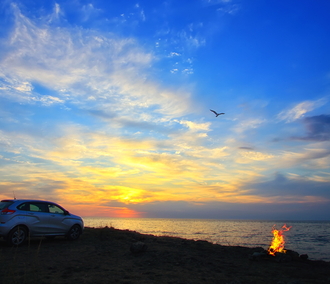 car beach with bonfire