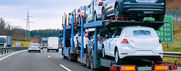 Car carrier transporter truck on road. Auto vehicles hauler on driveway.